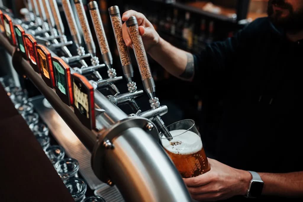 Barman nalewa piwo z baterii nalewaków w barze BGH